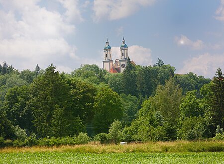 Blick auf die beiden Türme von Kloster Holzen mit davor liegendem Wald.
