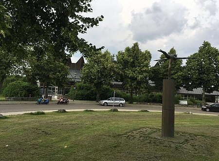 Das Bild zeigt eine Statue im Stauferpark darum sehr viel grün mit Sträuchern, Bäumen usw.